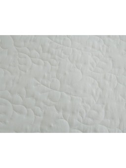 Colcha bordada con dibujo floral en color blanco y puntilla.