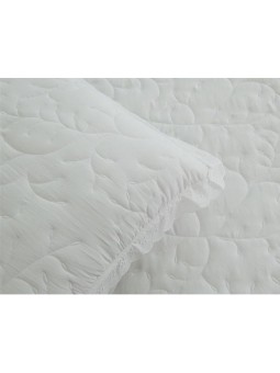 Colcha bordada con dibujo floral en color blanco y puntilla.