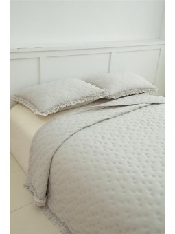 Vista frontal de la colcha Zoe en color beige con topitos y volante