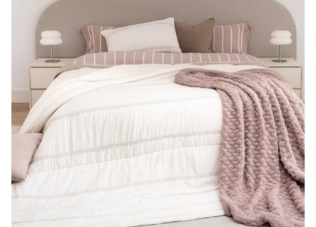 Edredón gris claro con bordado Tafel en composición de cama con accesorios de manta y cojines. Imagen ampliada