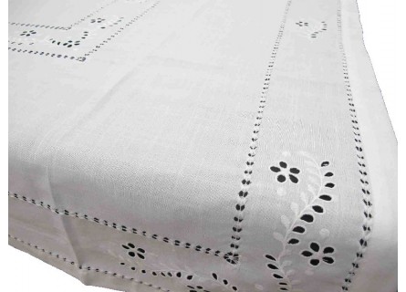 Mantel blanco bordado con dibujo calado de flor blanca.