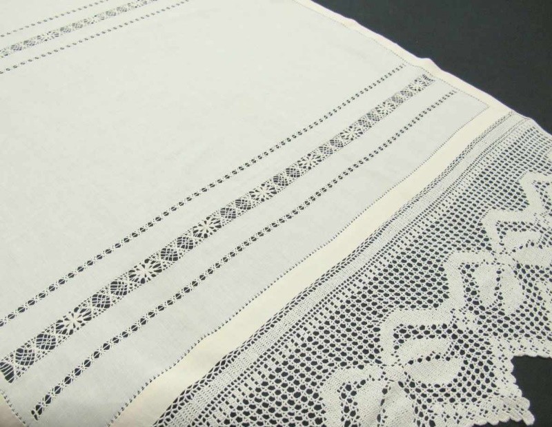 Cortina de hoja de ventana de hilo con bolillos en color beige.