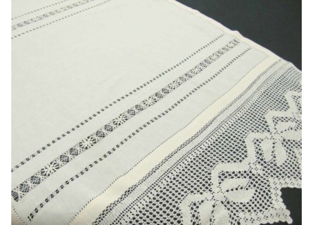 Cortina de hoja de ventana de hilo con bolillos en color beige.