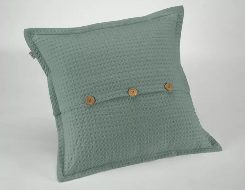 Funda de cojín de nido de abeja waffle en color verde con diseño de botones madera.