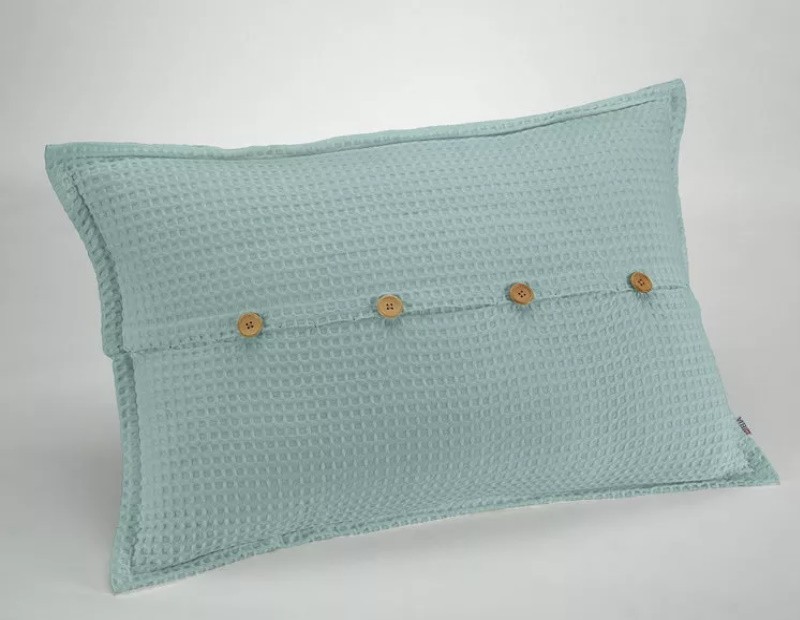 Funda de cojín de nido de abeja waffle en color verde agua con diseño de botones madera.