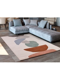 Alfombra con diseño geométrico o en color gris, azul, verde, caldera y coral con fondo natural.