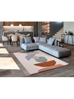 Alfombra con diseño geométrico o en color gris, azul, verde, caldera y coral con fondo natural.
