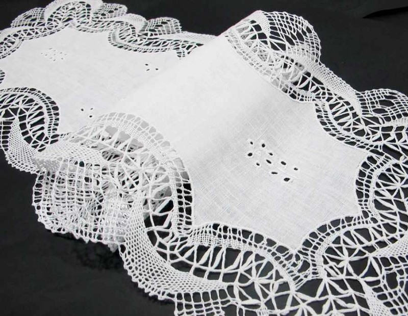 Tapete o camino de mesa hecho a mano con encaje de bolillos y vainicas en color blanco.