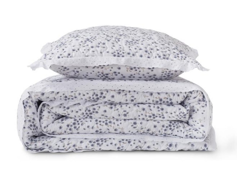 Colcha con estampado de flor liberty en azul y blanco. Estilo lencera terminada en tira bordada.