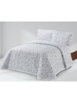 Colcha con estampado de flor liberty en azul y blanco. Estilo lencera terminada en tira bordada.