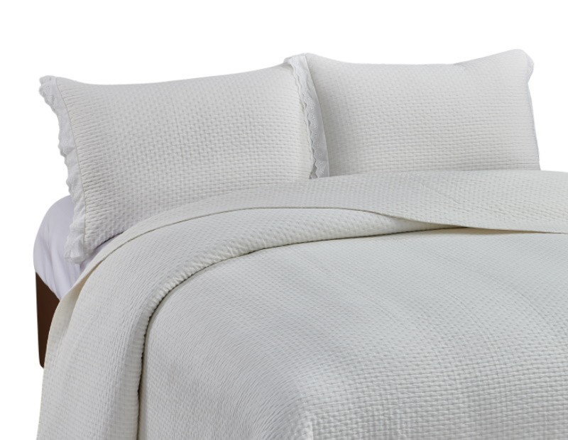 Colcha lencera en liso color beige natural con terminado en volante bordado.