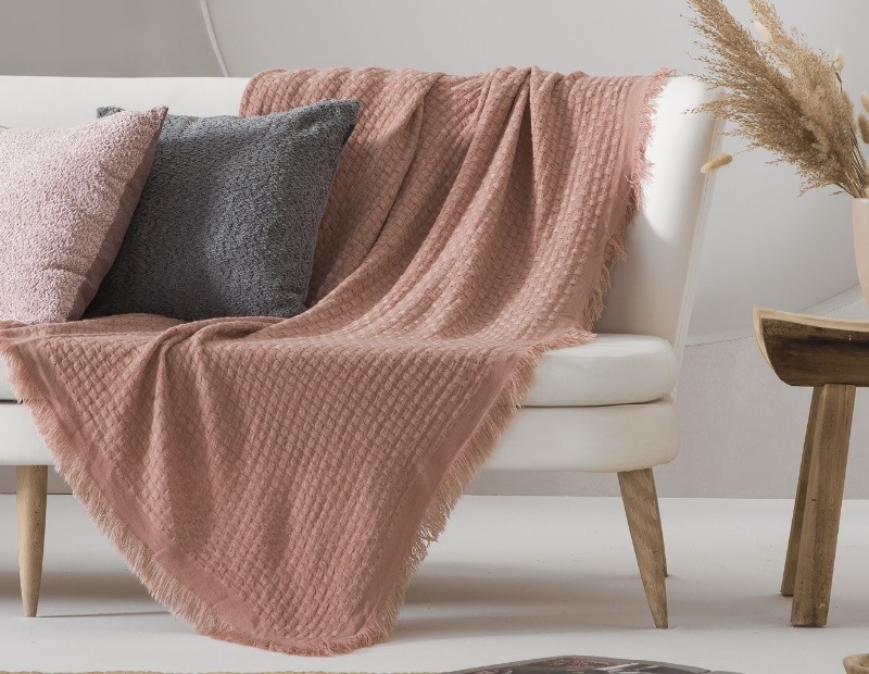Manta para sofá o cama de tamaño grande en color rosa de tacto muy suave. Modelo Ava de Textil Antilo.